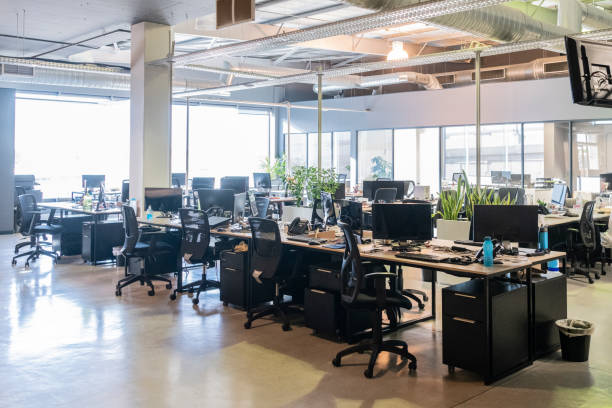 Modern office with desks and chairs, natural light coming though window, spacious work environment